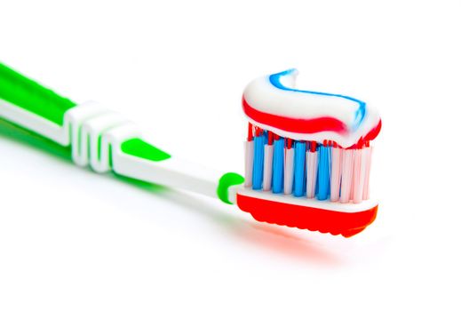 toothbrush with tricolor toothpaste isolated on a white background