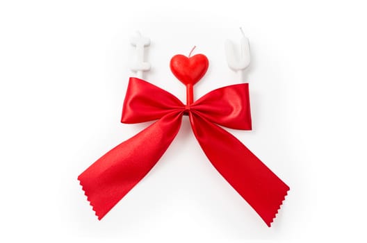 Red gift bow and  candles making 'I love you' isolated on white (clipping path included)   