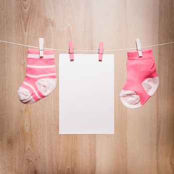 Baby girl socks attached to the rope and blank card