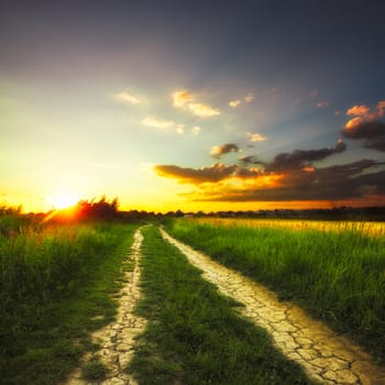 Path in the field and sunset. Rural landscape