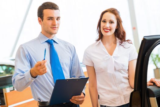 car salesman declares a young girl advantages of the new car