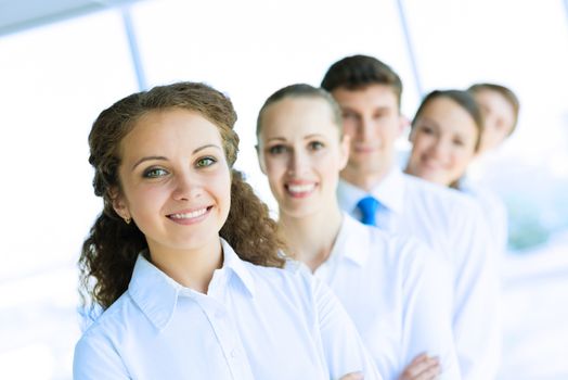 portrait of a young business woman standing in line with colleagues, concept of teamwork