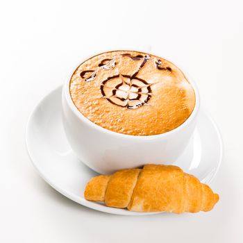 large cup of coffee with a pattern on foams and croissants, an early breakfast