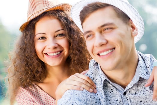 romantic couple lying on the grass in the summer park, spending time with loved ones