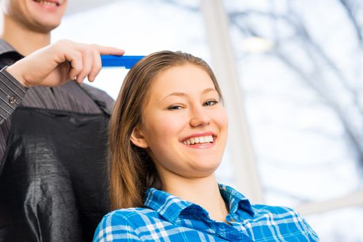 male hairdresser puts woman's hair in a hairdressing salon