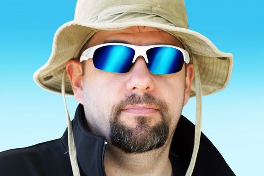 Portrait of a man during outdoor expedition with sun hat and mirror sunglasses