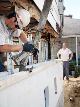 Construction or reno: pouring concrete in recycled styrofoam blocks to make foundation under lifted house