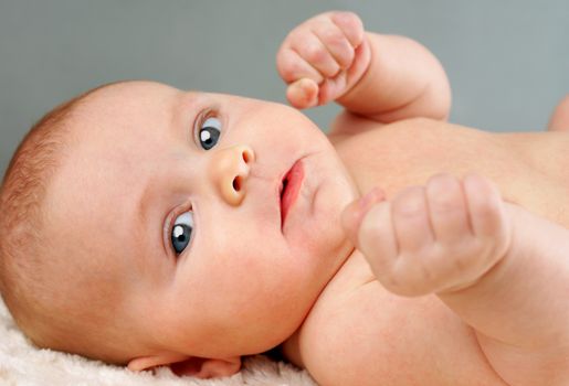 Funny shot of little baby with fists up, as if ready to fight