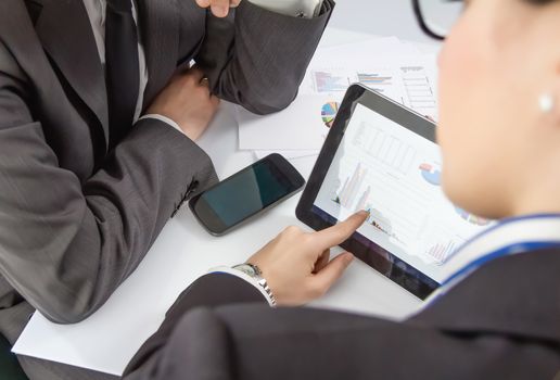 Businesswoman showing financial charts and documents in a digital tablet to the company boss