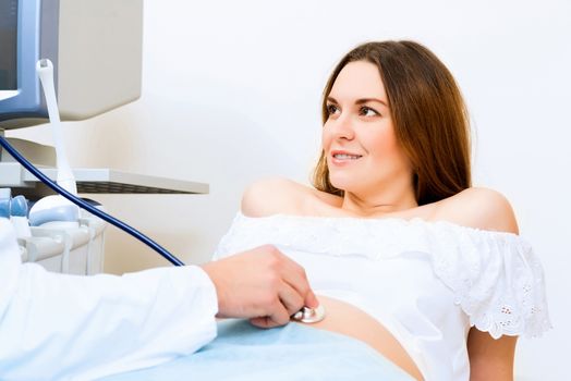 Young attractive pregnant woman on reception at the doctor, health check