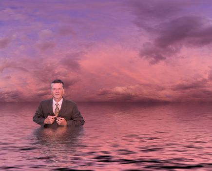 Conceptual image of senior businessman in suit up to waist in deep water. Man is looking proud and confident and the sunset reflects an image of success and not drowning in problems