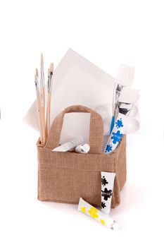 a bag with drawing and painting equipment on a white background