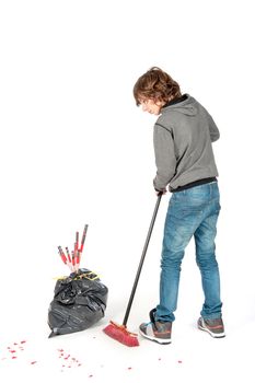 a teenage boy with a broom, cleaning the mess on new years day