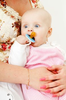 beautiful baby girl with pacifier at my mother's hands