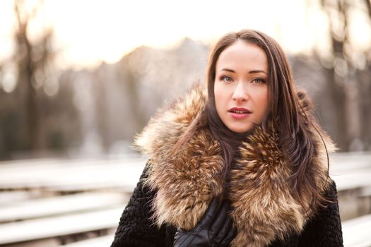 Beautiful lady is wearing a fur coat during the winter season