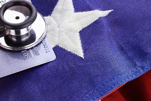 Stethoscope placed over American flag and credit card. 