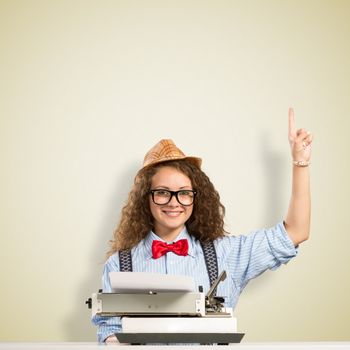 image of a young woman writer at the table with typewriter