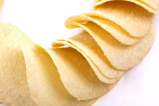 Tasty potato crisps (chips) isolated on a white background