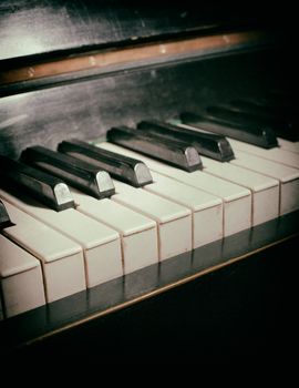 Old piano keyboard close up as a music background. With dust and scratches paper texture