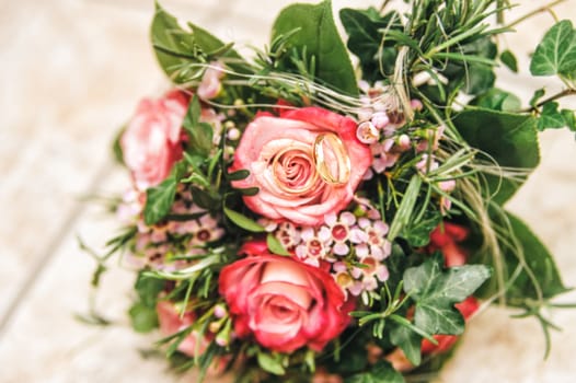 Two wedding rings on a bridal bouquet