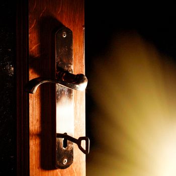 Open door with key into the dark room with light