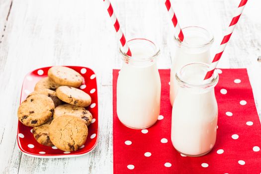 Milk in bottle with paper straw with cookies