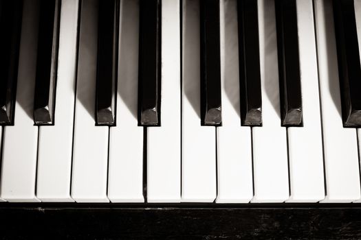 Old piano keyboard close up as a music background. Black and white image