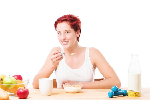 happy woman eating cornflakes at fitness breakfast on white background