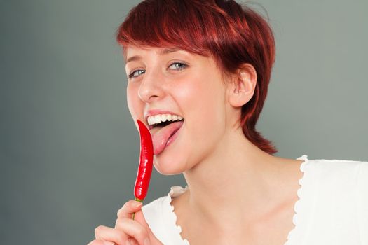 happy redhead woman licking on a spicy pepperoni