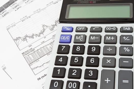 Close-up photo of business objects: calculator and diagrams