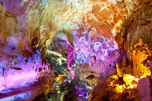 Sataplia cave in Georgia illuminated by colorful lights