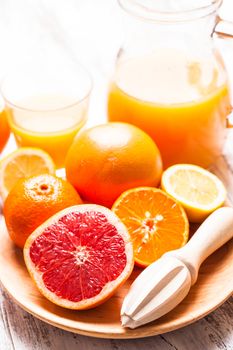 The preparation for citrus juice for breakfast. Wooden  citrus reamer with fruits.