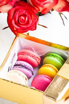 macaroons in gift box and roses in vase