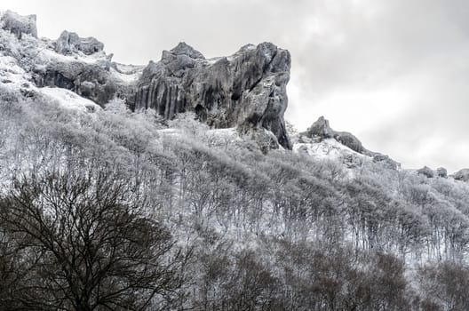 Beautiful winter picture at the rocks on the mountain. They are covered with snow and ice.