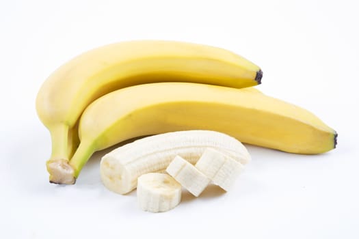 The ripe bananas with pieces on a white background.