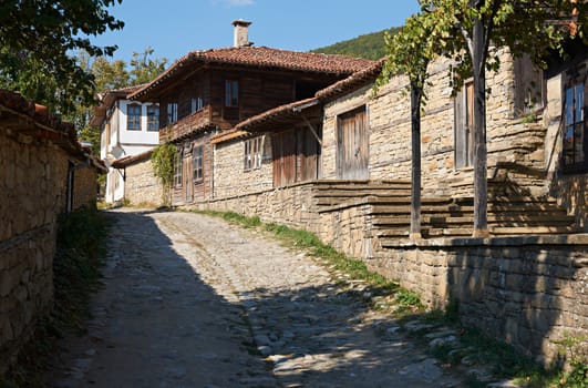 Summer street in Bulgarian revival village Zheravna with wooden houses amd stone-paved street