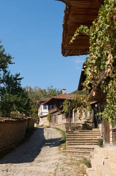 Summer street in Bulgarian revival village Zheravna with wooden houses amd stone-paved street