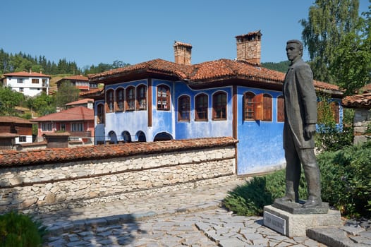 Street and house in Koprivshtitsa, Bulgaria with the monument of Todor Kableshkov