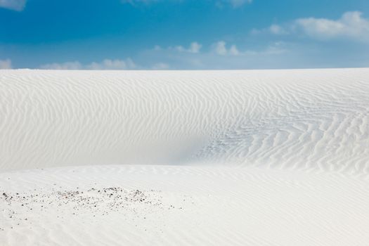 Desert scenery with white quartz sand and blue sky