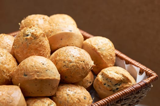 Salt muffins with olives and yellow cheese in bamboo kitchen basket