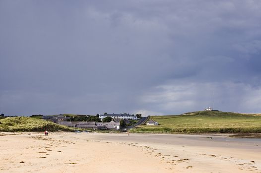 The pretty village of Low Newton by the Sea in Northumberland with heavy rainclouds gathering