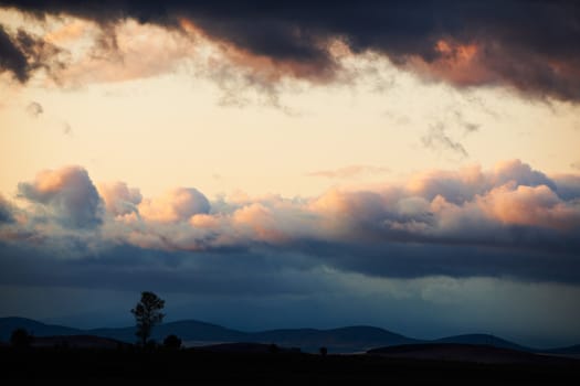 Sunset landscape with dark storm clouds after autumn rain