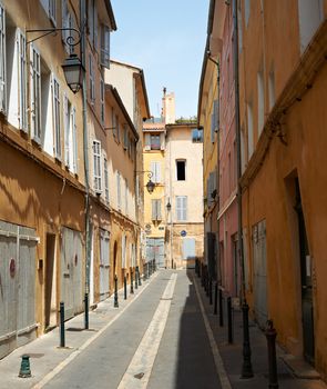 Narrow street with typical medieval buildings in Aix en Provence town, South France