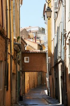 Narrow street with typical medieval buildings in Aix en Provence town, South France