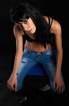 Sexy girl with jeans and black bra on black background