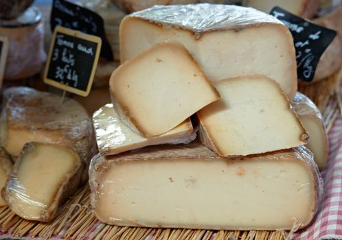 Sliced yellow French cheese at Provence market, in France