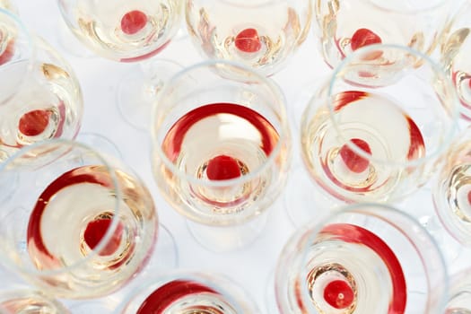 Multiple party glasses with red cherry drink on table