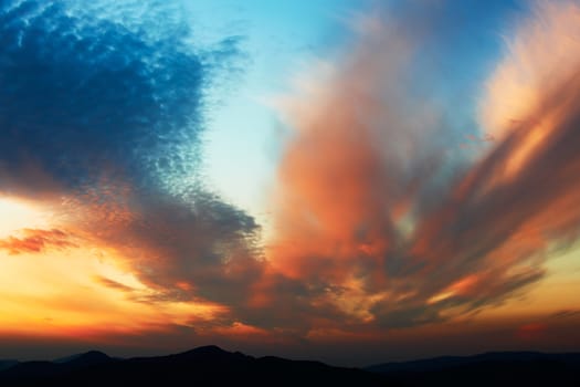 Beautiful colored sunset and sky over mountain ridges