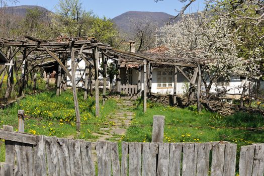 Fence and yard of traditional Bulgarian rural house in spring season