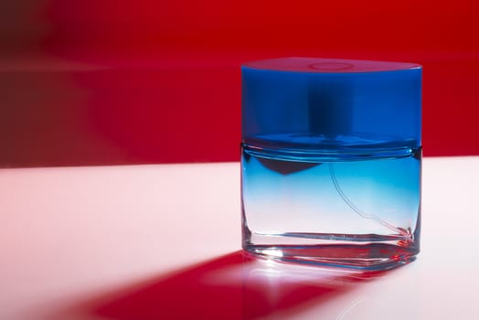 Blue perfume bottle on purple background with red shadow